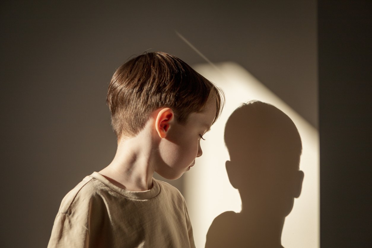 Indoor high contrast close up portrait of white 5 year old boy