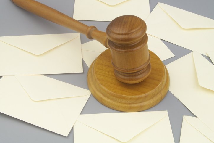 Court notification concept. Judge gavel and many letters on gray background.