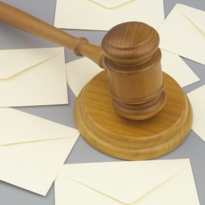 Court notification concept. Judge gavel and many letters on gray background.