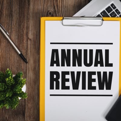 Annual Review on Clipboard over Wooden Work Desk