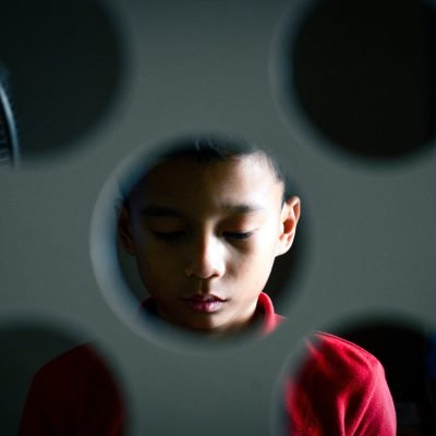 Boy Seen Through Perforated Metal
