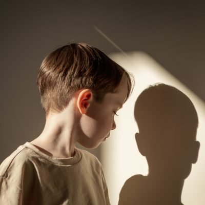 Indoor high contrast close up portrait of white 5 year old boy